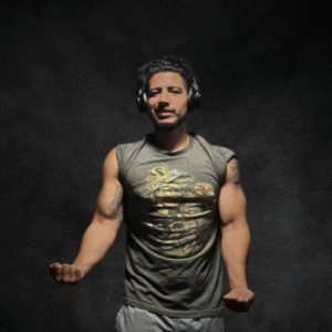Rudy, a San Antonio fitness coach, showing muscular arms in a sleeveless shirt with headphones